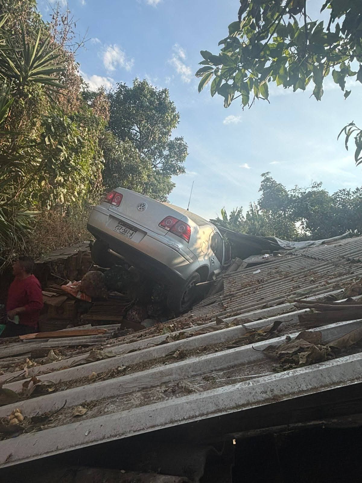 Tras choque con motocicleta, auto termina en el techo de una vivienda en Zitácuaro